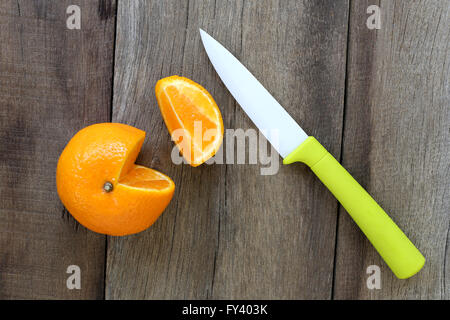 Mandarinen und Acryl Messer platziert auf dem alten Holzboden, Design-Konzept für über gesunde Lebensmittel. Stockfoto