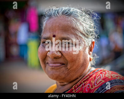 Inderin, die entlang der Straße in Kuilapalayam schaut die Kamera und das Lächeln Stockfoto