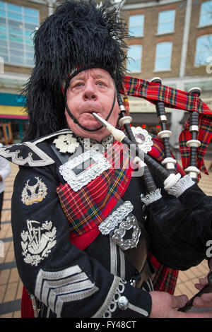 Wimbledon, London, UK. 21. April 2016. Pipe Major Tony Kelly Rohre in den Beginn der Leuchtturm Beleuchtungszeremonie auf der Piazza in Wimbledon Stadt Zentrum als Teil der internationalen Leuchtturm Beleuchtung Veranstaltung zum 90. Geburtstag der Queen zu feiern. Wimbledon ist Standort eines der vier Baken quer durch London beleuchtet werden. Bildnachweis: Malcolm Park Leitartikel/Alamy Live-Nachrichten. Stockfoto