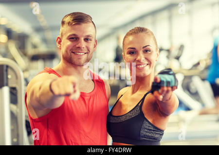 glücklicher Mann und Frau Zeigefinger auf Sie im Fitness-Studio Stockfoto