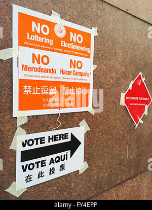 "Keine bummeln oder Electionering" und "Stimmen hier" Hinweisschilder in Englisch, Spanisch und Chinesisch, Wahlposition NYC, USA Stockfoto