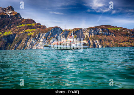 SISIKON, Schweiz - 10. April 2016 - Dampfschiff auf dem Vierwaldstättersee mit Blick auf die Schweizer Alpen von Sisikon, Schweiz. Stockfoto