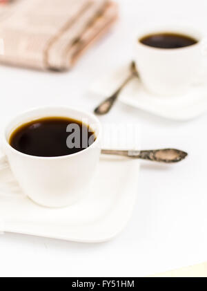 Zeitung und weißen Tasse Kaffee auf weißem Hintergrund Stockfoto