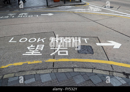 "Look rechts" Schild gemalt auf der Straße in Englisch und Chinesisch, Fußgänger, von welcher, die Seite Straßenverkehr kommt, zu informieren. Stockfoto