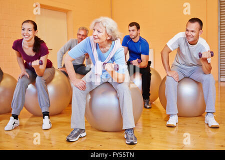 Glückliche Gruppe Rückentraining Übungen im Fitnessstudio mit Hanteln Stockfoto