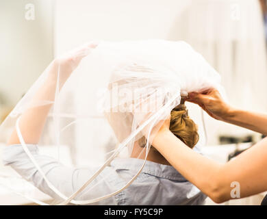 Stylist Anheften einer Braut Frisur und Brautschleier vor der Hochzeit Stockfoto