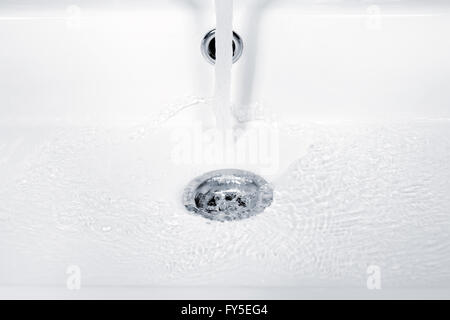 Das fließende Wasser, Wellen und Luftblasen im weißen Waschbecken Stockfoto
