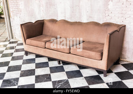 Antikes Sofa vor alten Stuck-Hintergrund Stockfoto