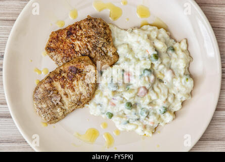 Gebratenes Filet vom Schwein mit Kartoffelsalat Mayonnaise auf dem Teller. Essen-Thema. Stockfoto