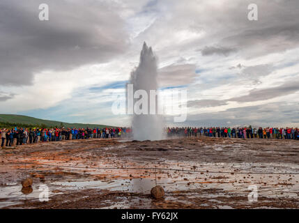 Haukadalur geothermische Gebiet, Süd-West Island, Island. 4. August 2015. (Drei in einer Reihe) Hunderte von Touristen versammeln sich um Strokkur Geysir ausbrechen, senden eine Spalte mit Dampf, Heißwasser und Dampf gen Himmel beobachten. Ein Brunnen Geysir im Haukadalur geothermische Bereich im Südwesten Islands, berühmten Strokkur bricht über alle 8 bis 10 Minuten, 15 bis 20 m hoch (49 ft bis 65 ft), manchmal so hoch wie 40 m (130 ft). Es ist eine beliebte beliebte Attraktion in Island, wo Tourismus ein wachsender Sektor der Wirtschaft geworden. © Arnold Drapkin/ZUMA Draht/Alamy Live-Nachrichten Stockfoto