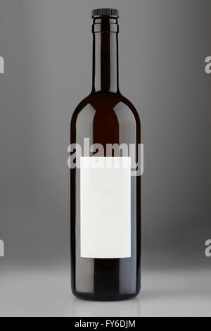 Flasche Rotwein mit Mütze und leere Beschriftung auf grauem Hintergrund, Clipping-Pfad Stockfoto