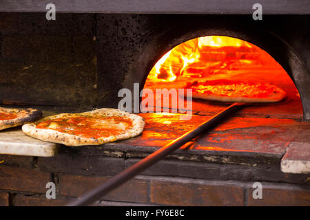 Blick ins Innere ein Holzbefeuerter Pizzaofen an Pizzen in berühmten italienischen Restaurant in Neapel, Pizzeria da Michele Stockfoto