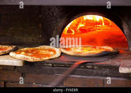 Blick ins Innere ein Holzbefeuerter Pizzaofen an Pizzen in berühmten italienischen Restaurant in Neapel, Pizzeria da Michele Stockfoto