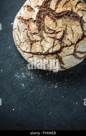 Artisan Vollkorn Roggenbrot, auf dunkle Schiefer. Zutaten-Rand-Hintergrund Stockfoto