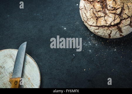 Artisan Vollkorn Roggenbrot, auf dunkle Schiefer. Zutaten-Rand-Hintergrund Stockfoto