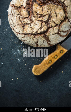 Artisan Vollkorn Roggenbrot, auf dunkle Schiefer. Zutaten-Rand-Hintergrund Stockfoto