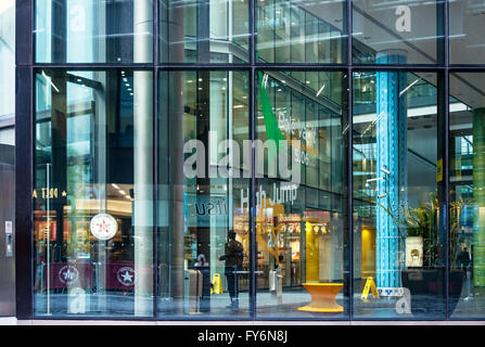 Ein Mann in eine riesige moderne Büro- und Gewerbe-block, in London, betrachtet durch die Glaswand Stockfoto