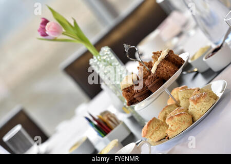 Tee in einem Unternehmensumfeld, Tulpen, Scones und Kuchen am Nachmittag Stockfoto