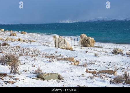 Felsen auf dem Schnee bedeckt Ufer der Laguna Verde im Winter im Torres Del Paine Nationalpark in Patagonien, Chile. Stockfoto