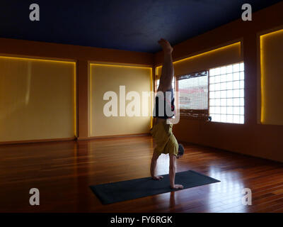 Mann Handstanding im Inneren ein Yoga-Studio Stockfoto