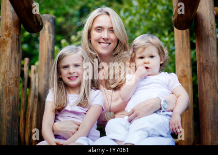 Lächelnde blonde Mutter und ihren beiden Töchtern Stockfoto