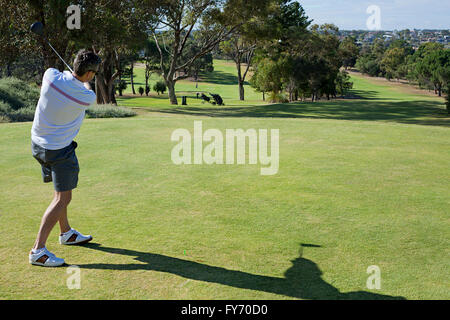 Ein junger Golfer in der Endplatzierung nach der Kollision mit eines Abschlag Stockfoto