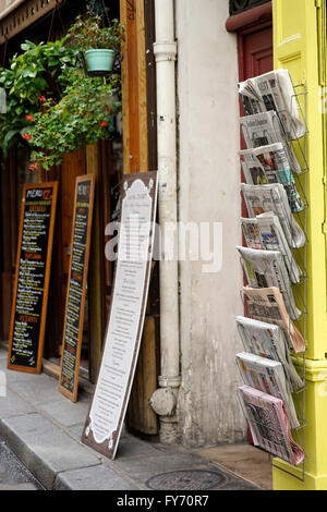 Zeitungen in verschiedenen Sprachen anzeigen außerhalb einem Schreibwarenladen in Saint-Germain-des-Pres, Paris, Frankreich Stockfoto