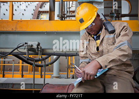 FQML Mitarbeiter bei Sentinel Kupfer-Mine in seinem Logbuch schreiben Stockfoto