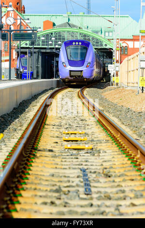 Trelleborg, Schweden - 12 April 2016: Lila Personenzug, Modell X61, stehend auf halbem Weg in den Bahnhof und auf halber Strecke outs Stockfoto