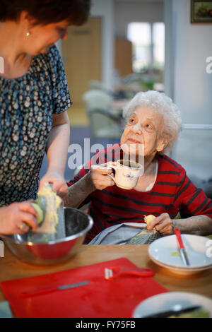 Frau, 89 Jahre, und eine Sozialarbeiterin, 31 Jahre, Kochen als ein Zeitvertreib für die Altenpflege, häusliche Krankenpflege Stockfoto