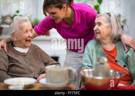 Zwei ältere Frauen, 78 Jahre und 88 Jahre und Betreuer für ältere Menschen, 31 Jahre, Freizeitaktivitäten in einem Pflegeheim Stockfoto