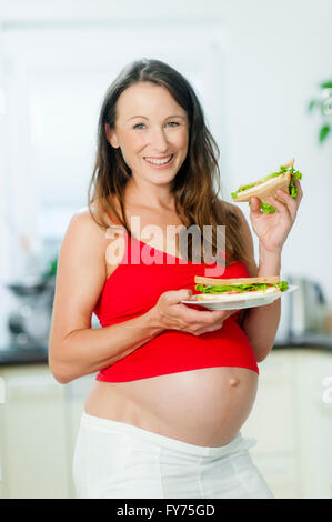 Schwangere Frau Holding sandwiches Stockfoto