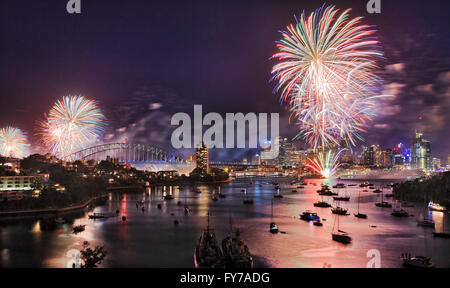 Sydney Neujahr Silvester Feuerwerk über dem Hafen mit Brücke und Stadt CBD Gebäuden reflektiert bunten Feuerkugeln in unscharfen Wasser. Stockfoto