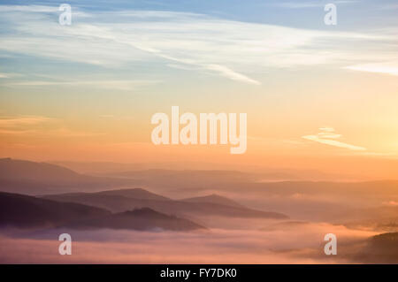 Blick auf ein Tal im frühen Morgen mit Nebel zwischen Hügeln Stockfoto