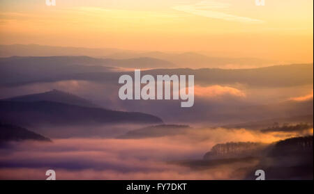 Blick auf ein Tal im frühen Morgen mit Nebel zwischen Hügeln Stockfoto