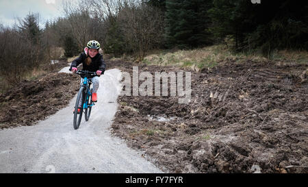Eine Mädchen reitet ein Fahrrad eine Off-Road-Strecke / track lächelnd Stockfoto