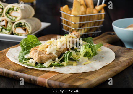 Panierte Chicken Burrito Wrap mit frischem Salat Käse auf rustikalen Hintergrund Stockfoto