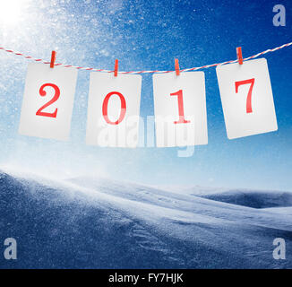 Papier oder Foto Rahmen mit 2017 Zahlen rot gestreiftes Seil hängen. Schneesturm im sonnigen Tag Hintergrund. Neujahr-design Stockfoto