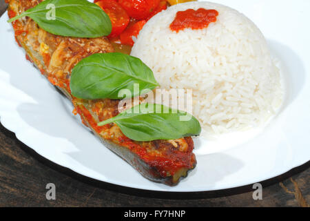 Gefüllte Zucchini, Reis, geschmorte Paprika und Tomaten, Gemüse, Beilagen, garniert mit Basilikum-Blätter auf einer Platte Stockfoto