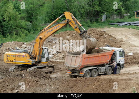 Bukarest, Rumänien, 19. April 2016: Ein Bagger arbeiten entfernen von Erde und laden in einen LKW-Kipper auf einem Bau-si Stockfoto