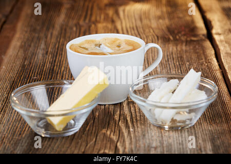 Kaffee, Butter und Kokosnussöl für kugelsichere Kaffee auf einem braunen Holztisch Stockfoto