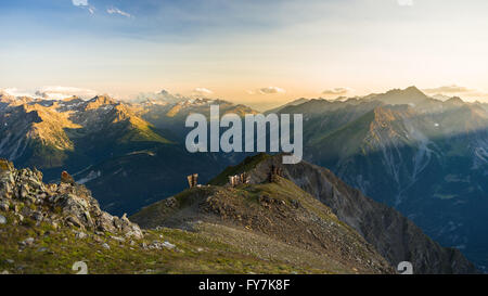 Letzte weiche Sonnenlicht über felsige Berggipfel, Grate und Täler der Alpen bei Sonnenaufgang. Extremen Gelände Landschaft am hohen altit Stockfoto