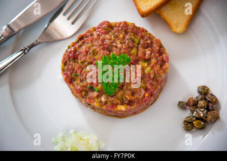 Beef Tatar mit Zwiebeln, Kapern und Toastbrot Stockfoto