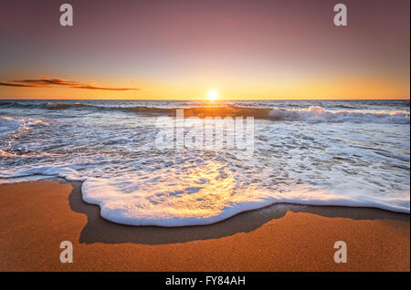 Bunte Meer Strand Sonnenaufgang mit tief blauen Himmel und Sonne Strahlen. Stockfoto