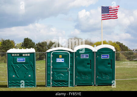 Reihe tragbarer Toiletten mit amerikanischen Sternen und Streifen, die auf dem St Georges Day Festival in Poole, Dorset, Großbritannien, fliegen Stockfoto