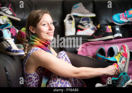 Ein junges Mädchen mit einer großen Sammlung von Trainer UK Stockfoto