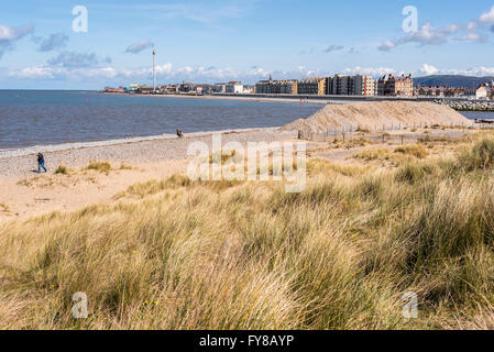 Der Kiesstrand am Eingang zum Hafen von Rhyl in Denbighshire Nord-Wales. Die Stadt am Meer im Hintergrund. Stockfoto