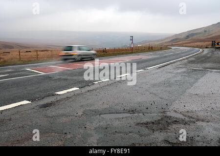 Ein Auto beschleunigt die A62 Strasse bei nasser Witterung in der Nähe von Marsden, Huddersfield, in Yorkshire Pennines, England, Großbritannien. Stockfoto