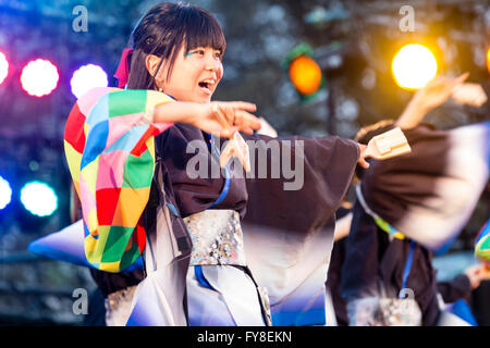 Junge Japanerin mit wirbelnden lange Ärmel, Teil der Dance Team, Tanzen auf der Bühne am Abend während Yosakoi Dance Festival in Kumamoto, Japan. Stockfoto