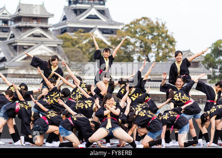 Japanische weibliche Tanzgruppe der Mädchen im Teenageralter, Tanzen auf der Bühne mit Kumamoto schloss hinter Ihnen, während der jährlichen Yosakoi Festival. Stockfoto